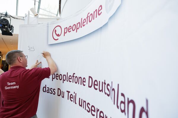 Männliche Person beschriftet mit einem Filzstift eine Messewand.