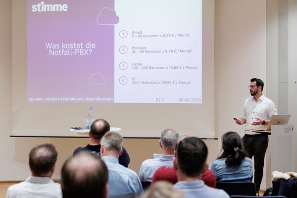 Eine Person steht vor einer Leinwand und hält einen Vortrag.