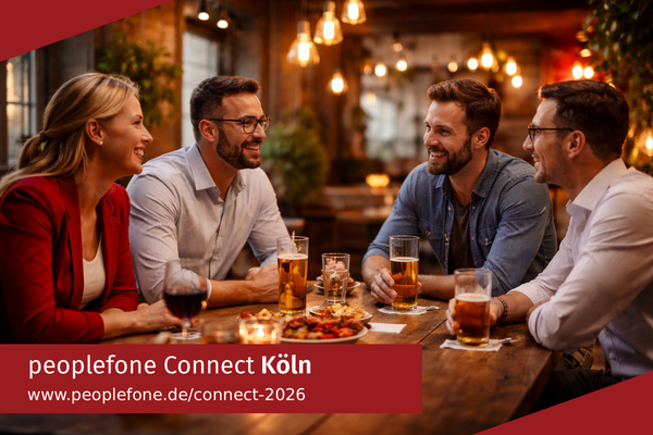 peoplefone Connect Köln. Personen sitzen an einem Holztisch und unterhalten sich.