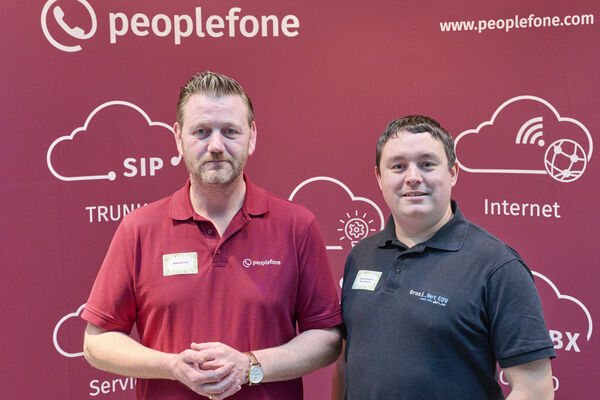 Partner der peoplefone stehen vor einer Fotowand