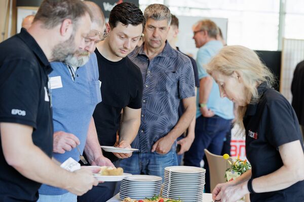 Mehrere Personen stehen am Buffet an und bedienen sich.