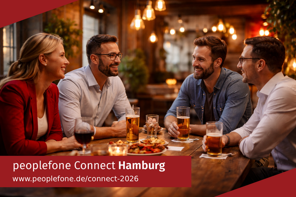 peoplefone Connect Hamburg. Personen sitzen an einem Holztisch und unterhalten sich.