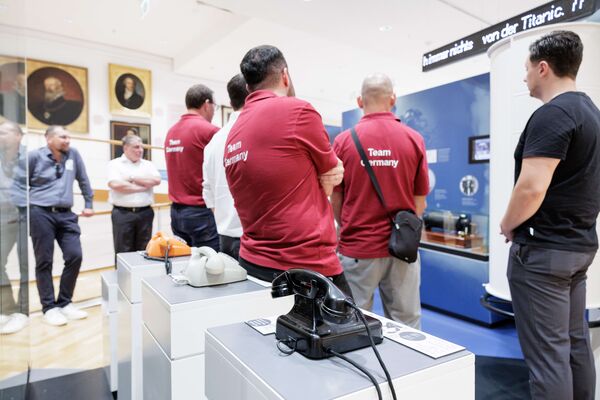 Mehrere Personen stehen in der Ausstellung und hören zu.