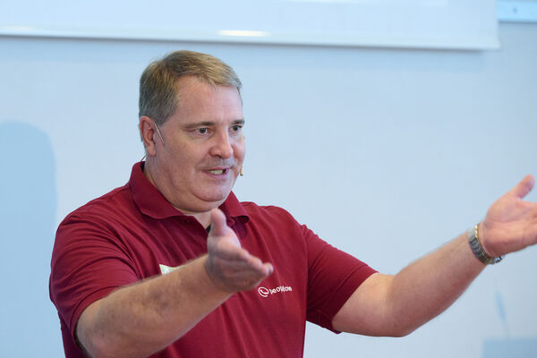 Felix Pflüger steht auf der Bühne und begrüßt die Gäste.