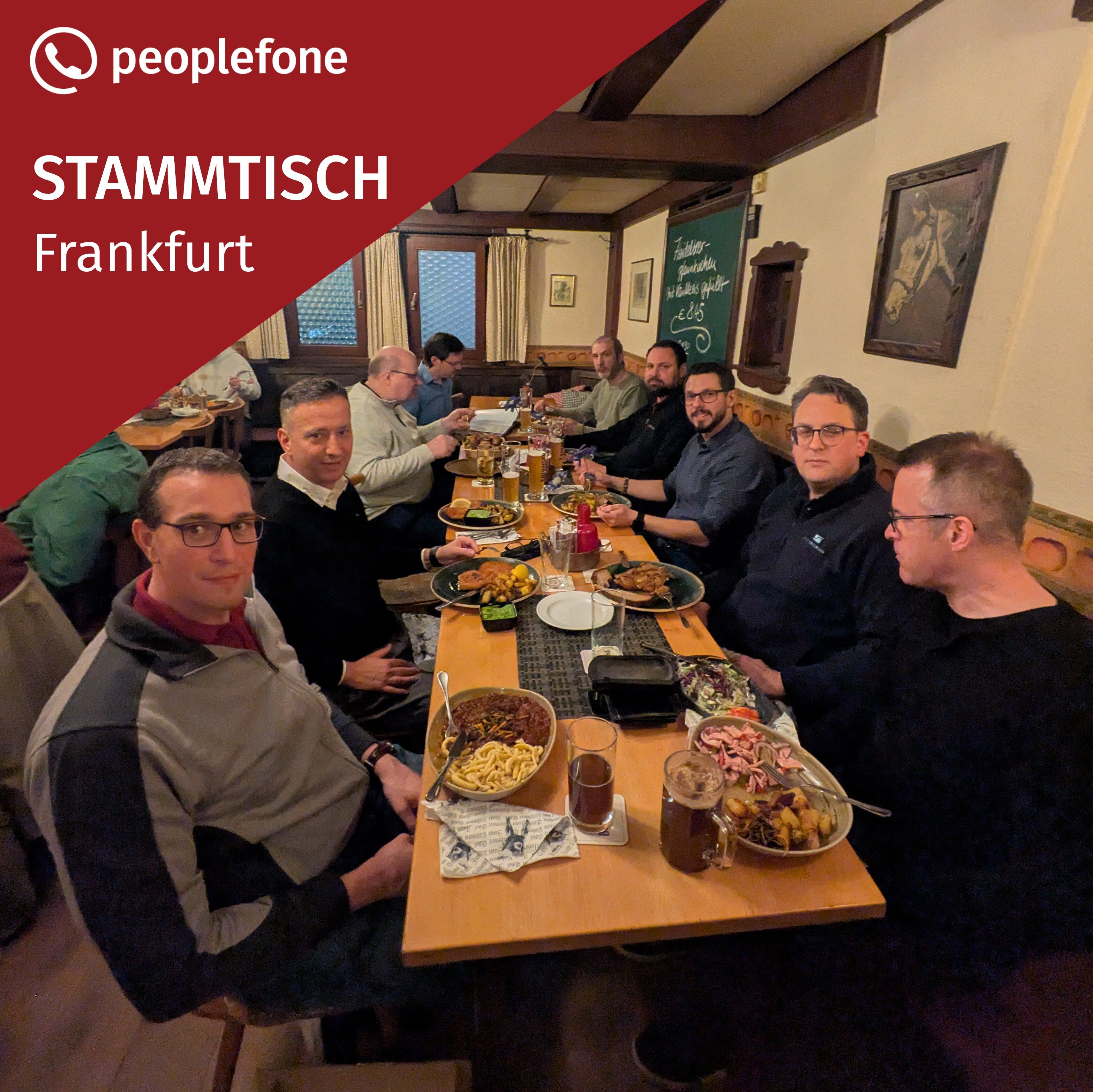 Mehrere Personen sitzen an einem langen Tisch und essen.