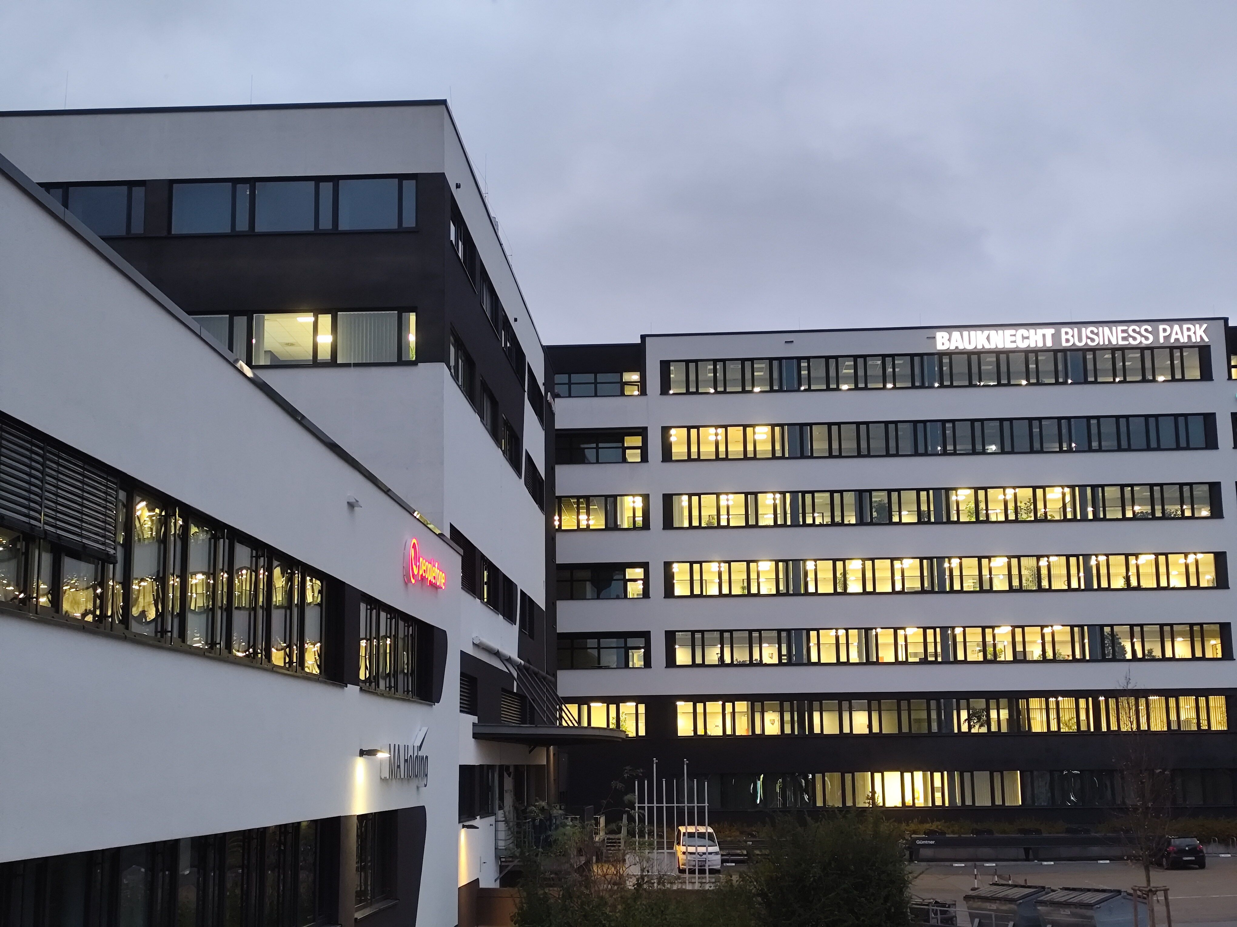 Firmengebäude von außen mit Beleuchtung.