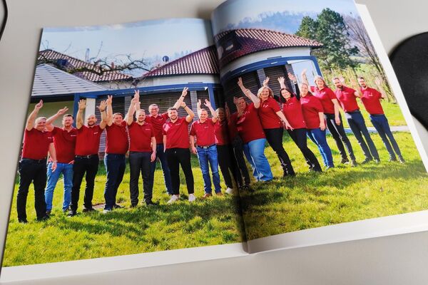 Aufgeschlagene Broschüre mit dem Team der peoplefone.