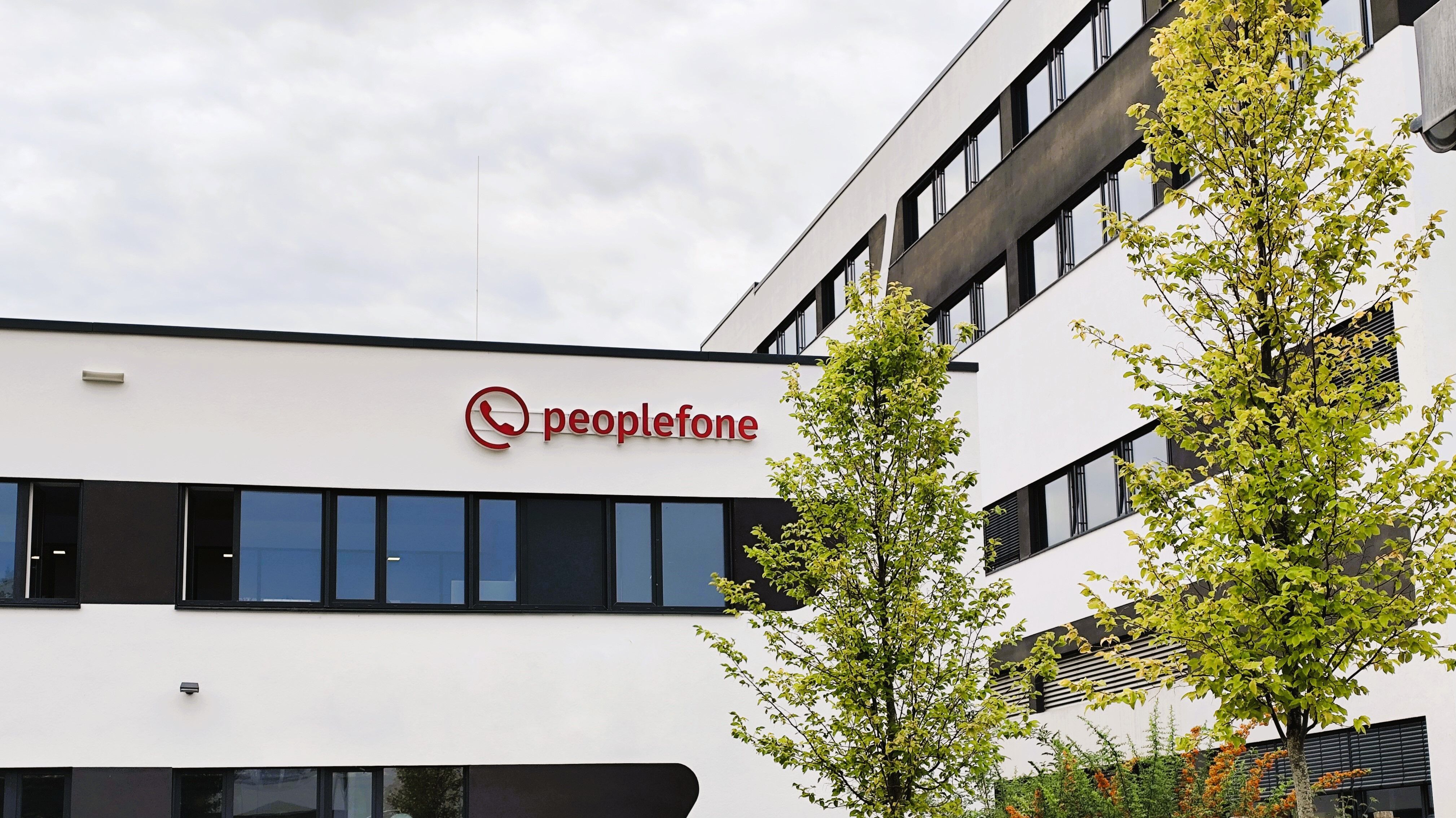 Unternehmensgebäude von außen mit peoplefone Logo.