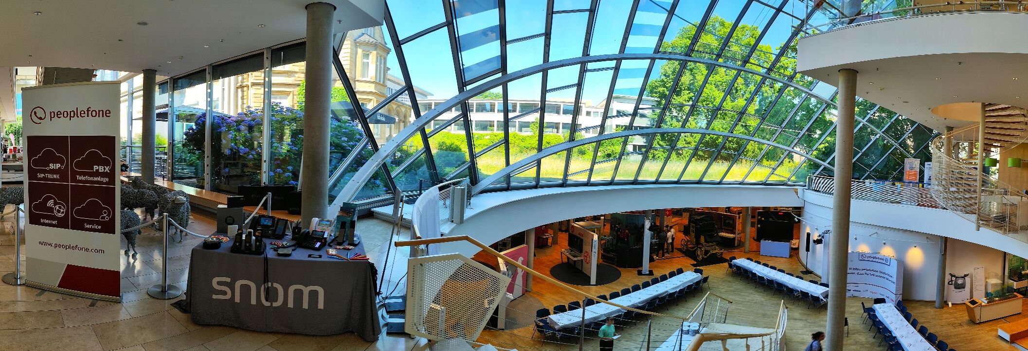 Blick in den Lichthof mit Bestuhlung, Tischen und Infowänden.