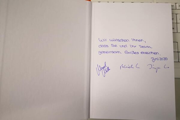 Eintrag und Unterschriften der Referenten in einem Buch auf der ersten Seite.