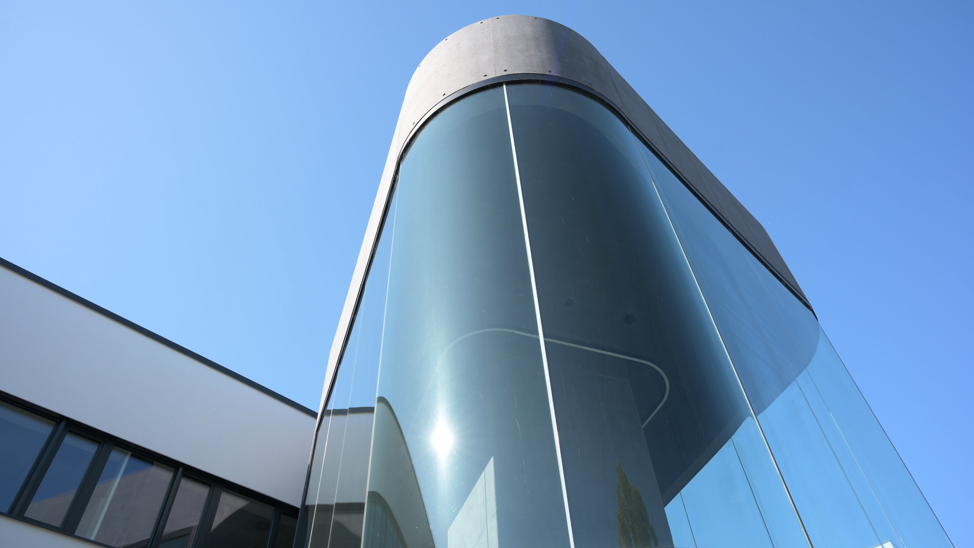 Treppenhaus aus Glas. Außenansicht des peoplefone Gebäudes.