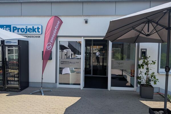 Eingang eines Firmengebäudes mit peoplefone Beachflag am Eingang.